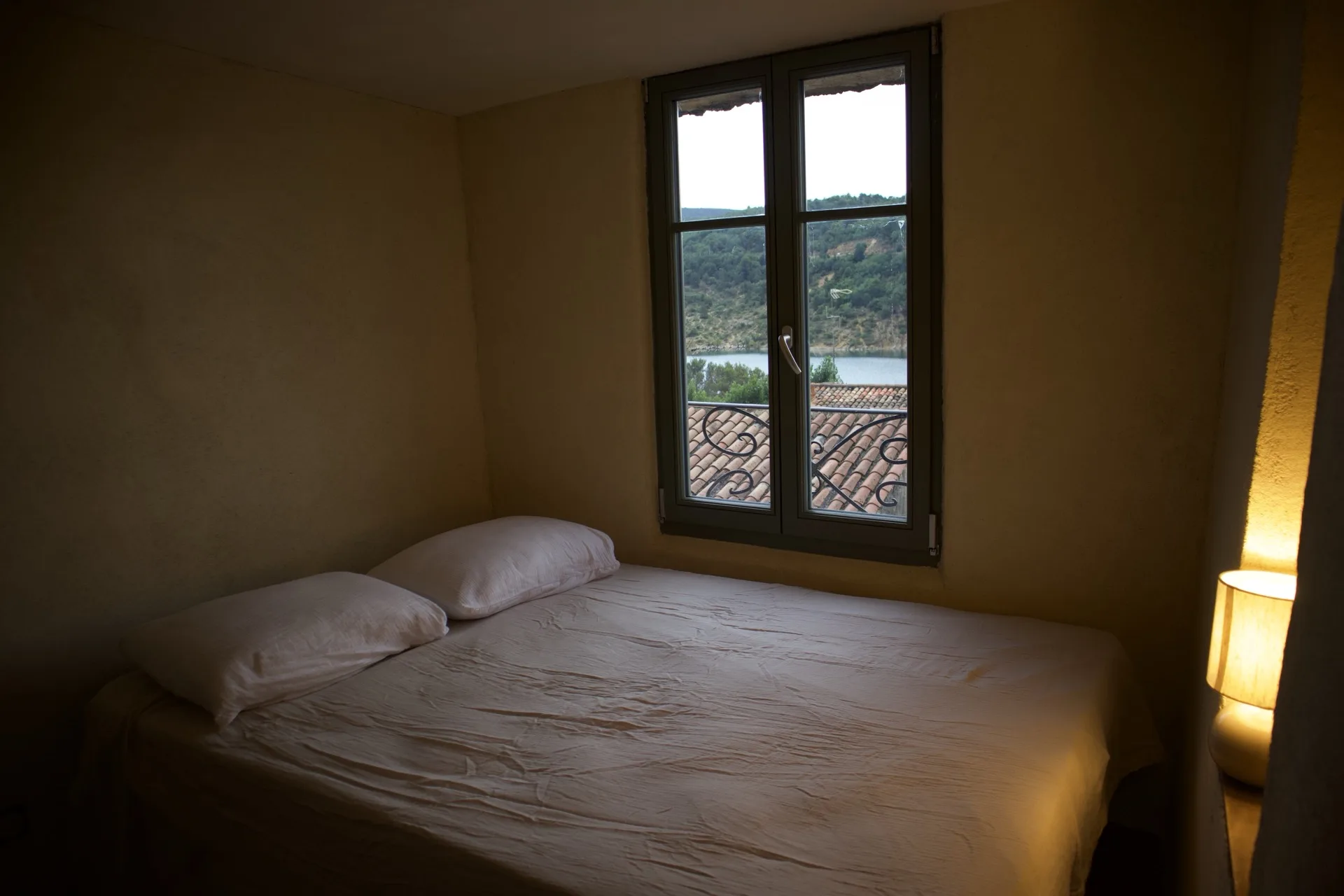Chambre avec lit double et fenêtre vue sur le lac