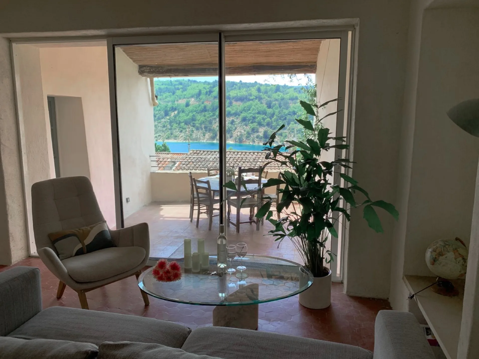 Salon, grandes baies vitrées ouvertes sur la terrasse et le lac