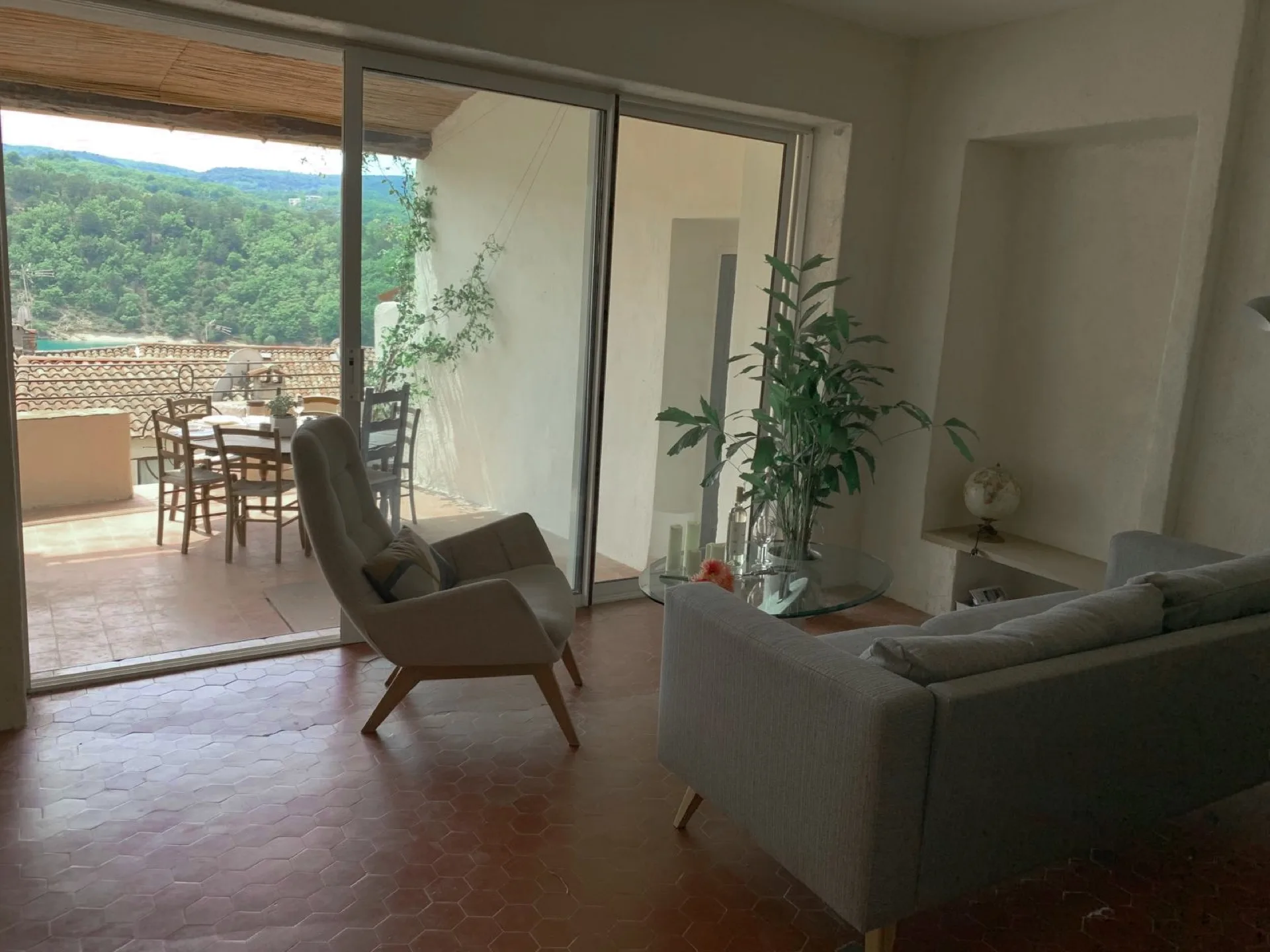 Grand salon avec fauteuils, accès direct à la terrasse