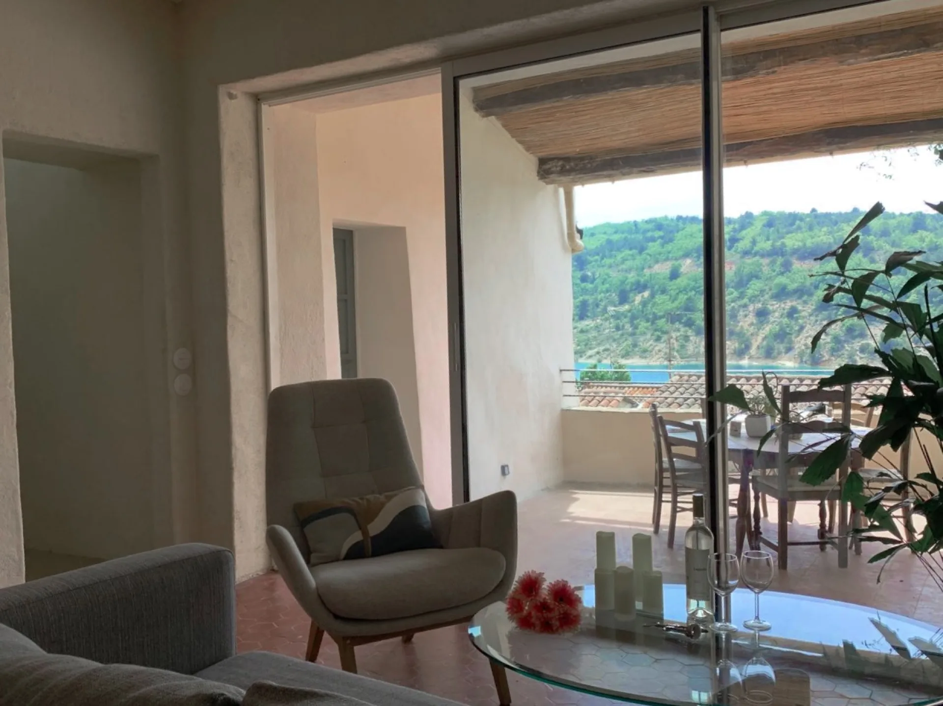 Salon avec table basse en verre, ouverture sur la terrasse et le lac